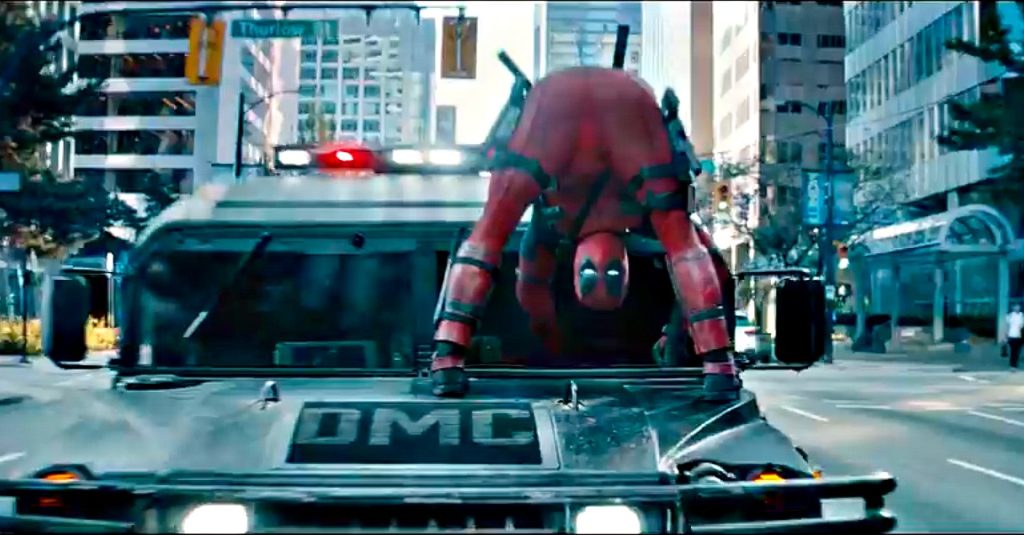 Deadpool est debout sur un capot de jeep, les fesses tendues vers la caméra